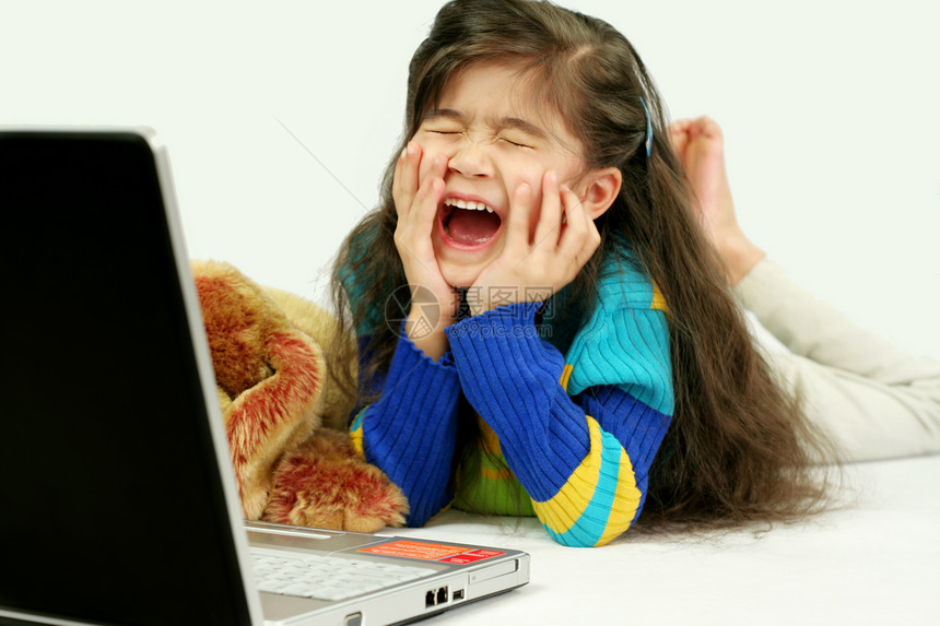 小女孩在地板上玩笔记本电脑混血儿女孩地面电子产品乐趣黑发长发混血享受微笑图片