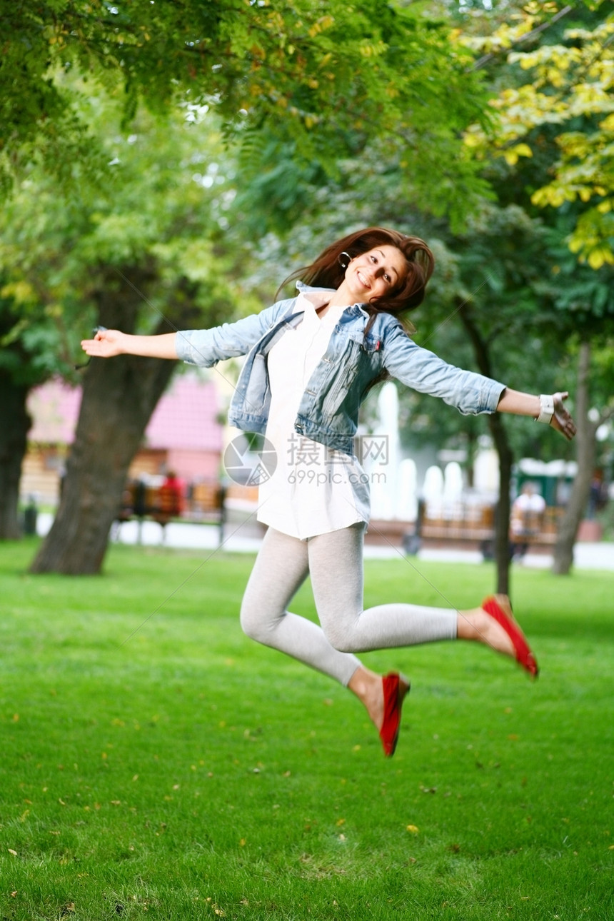 年轻女子在草地上乱晃乐趣舞蹈女孩微笑自由喜悦运动天空晴天头发图片