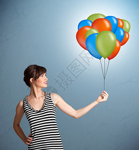 彩色条纹气球年轻女子拿着彩色气球庆典快乐女士闲暇演讲女性派对微笑玩具乐趣背景