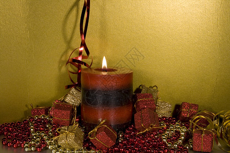 带点蜡烛的圣诞装饰品红色珠子火花礼物金子玩意儿飘带背景图片