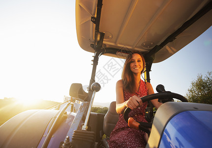 乡村女童驾驶农民生活阳光礼服日落国家拖拉机红色背景图片