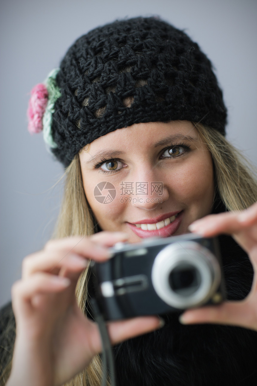 女孩用数码照相机拍摄照片图片