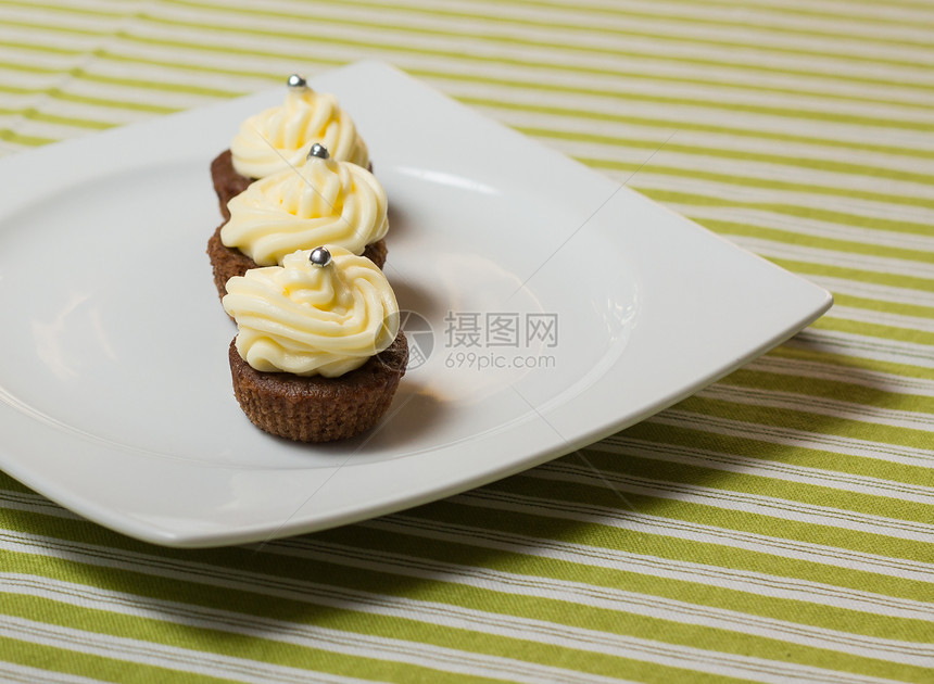 巧克力蛋糕 上面有银色的纸杯片 在白色盘子上冰镇黄油蛋糕奶油配料庆典小雨甜点美食巧克力图片