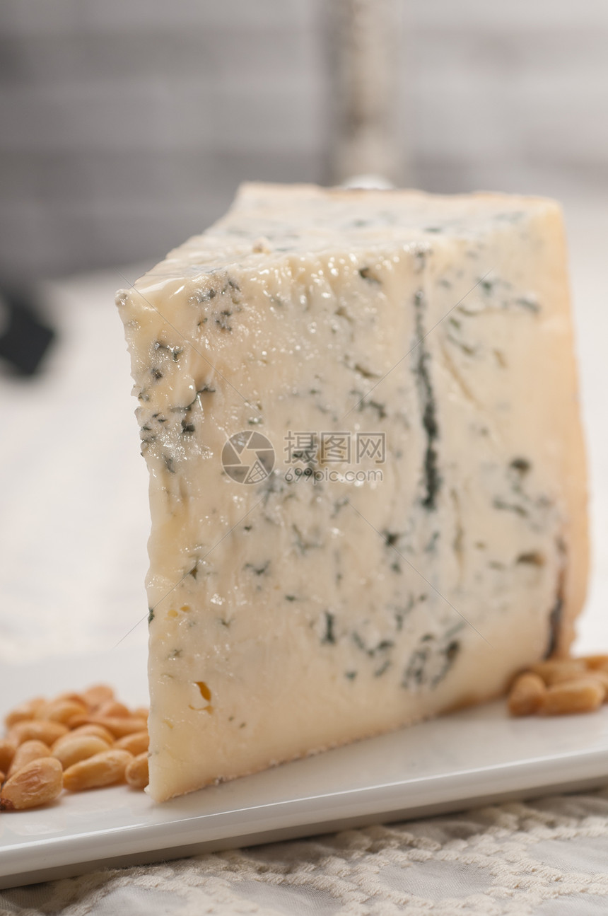 新鲜切干酪和松果奶制品牛奶三角形模具羊乳蓝色食物木板美食产品图片