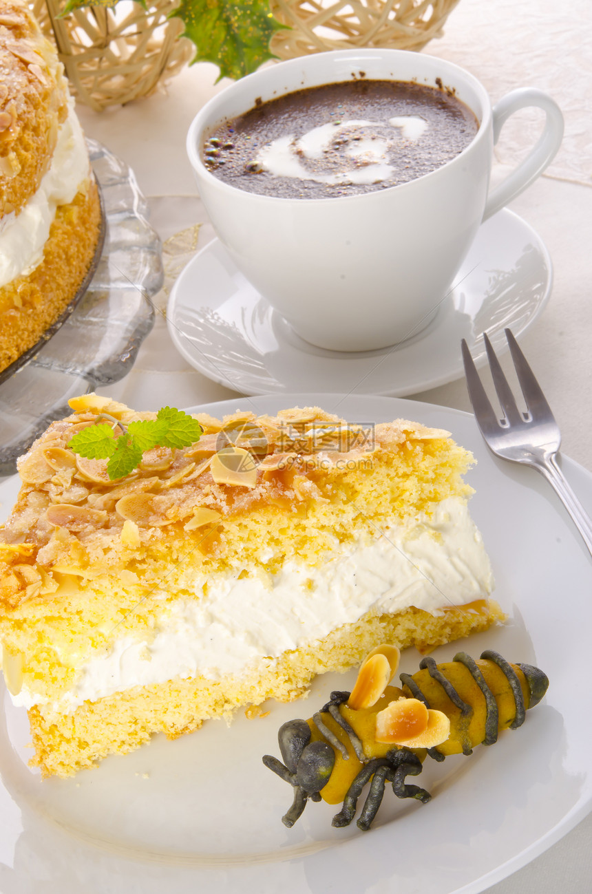 带有杏仁和糖涂层的扁蛋糕食物咖啡蜂蜜奶油桌子蜜蜂生日派对糕点坚果图片