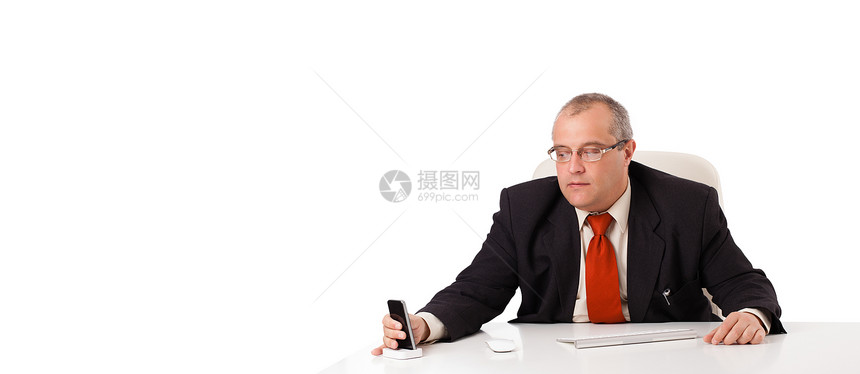 坐在办公桌的商务人士 手持带影印件的移动电话老板导演工人写作职业经济员工微笑工作键盘图片