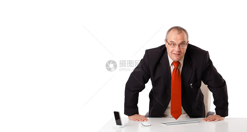 商业商坐在有复制空间的办公桌微笑男人导演电话老鼠键盘总务长文书职业签名图片