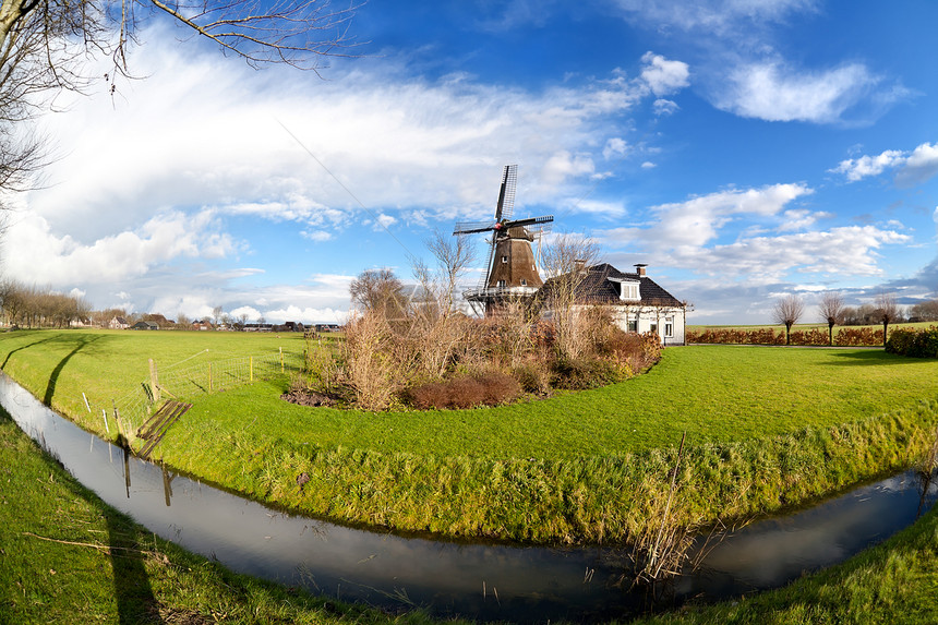 荷兰风车 在绿草牧场上用运河图片