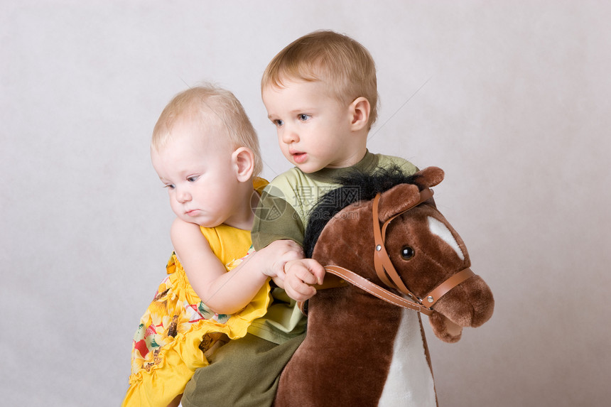 两个孩子在玩玩具马图片