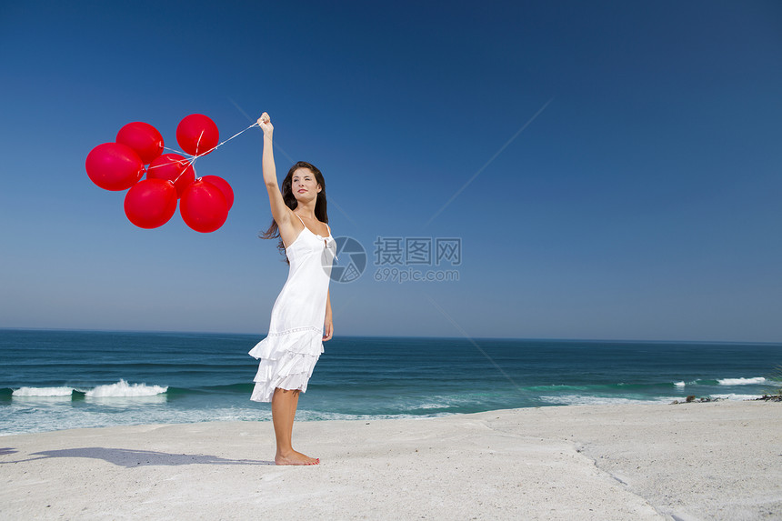 带着红色芭蕾舞的漂亮女孩成人海滩青年晴天飞行女孩海洋乐趣微笑自由图片