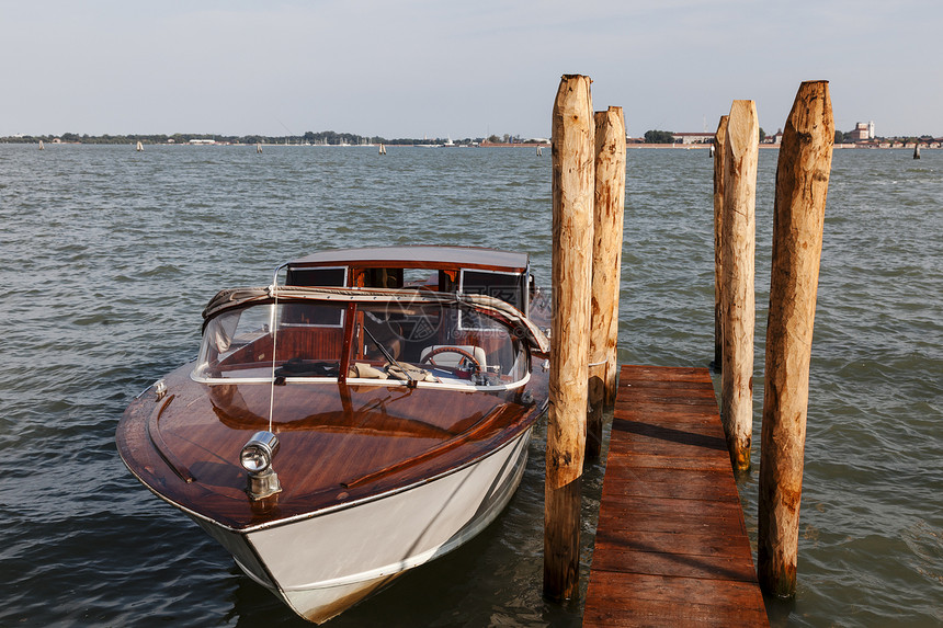 威尼斯的船木杆运输海洋汽艇两极出租车码头图片
