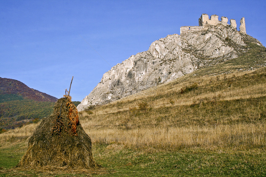 观望着托罗科森特吉奥尔吉的城堡废墟丘陵建筑学石头蓝色建筑天空草垛晴天历史性图片