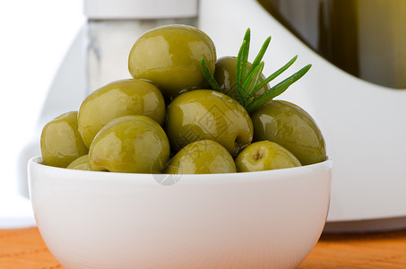 白陶瓷碗中的绿橄榄向日葵代谢味道油壶植物收成液体调味品处女烹饪背景图片