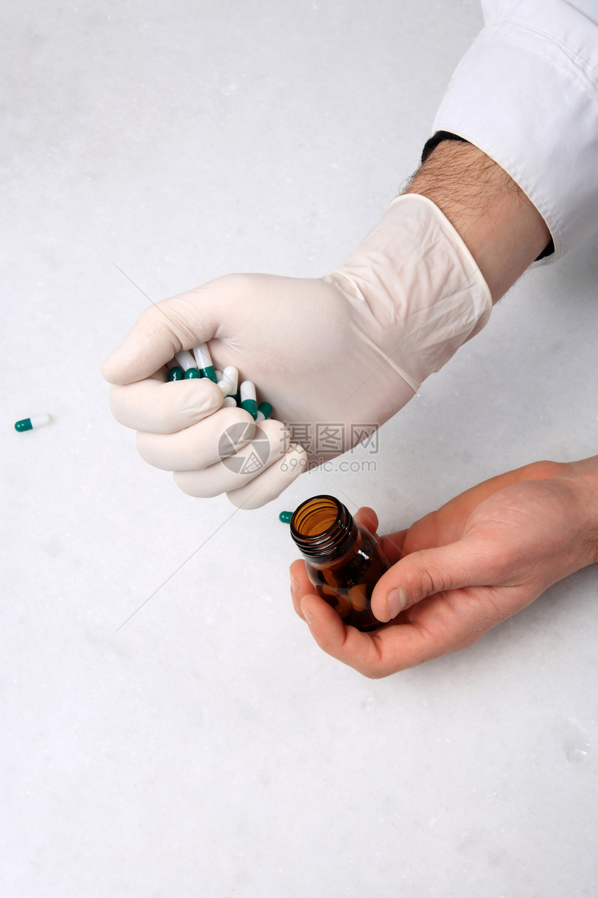 手和药丸药理胶囊白色药片团体化学品橙子瓶子玻璃化学图片