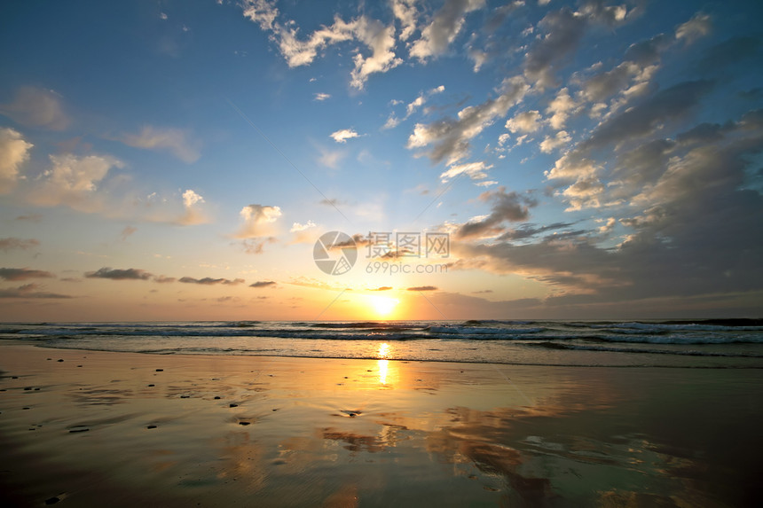 日落时沙滩上美丽的云彩风景海滩雕像海浪岩石图片