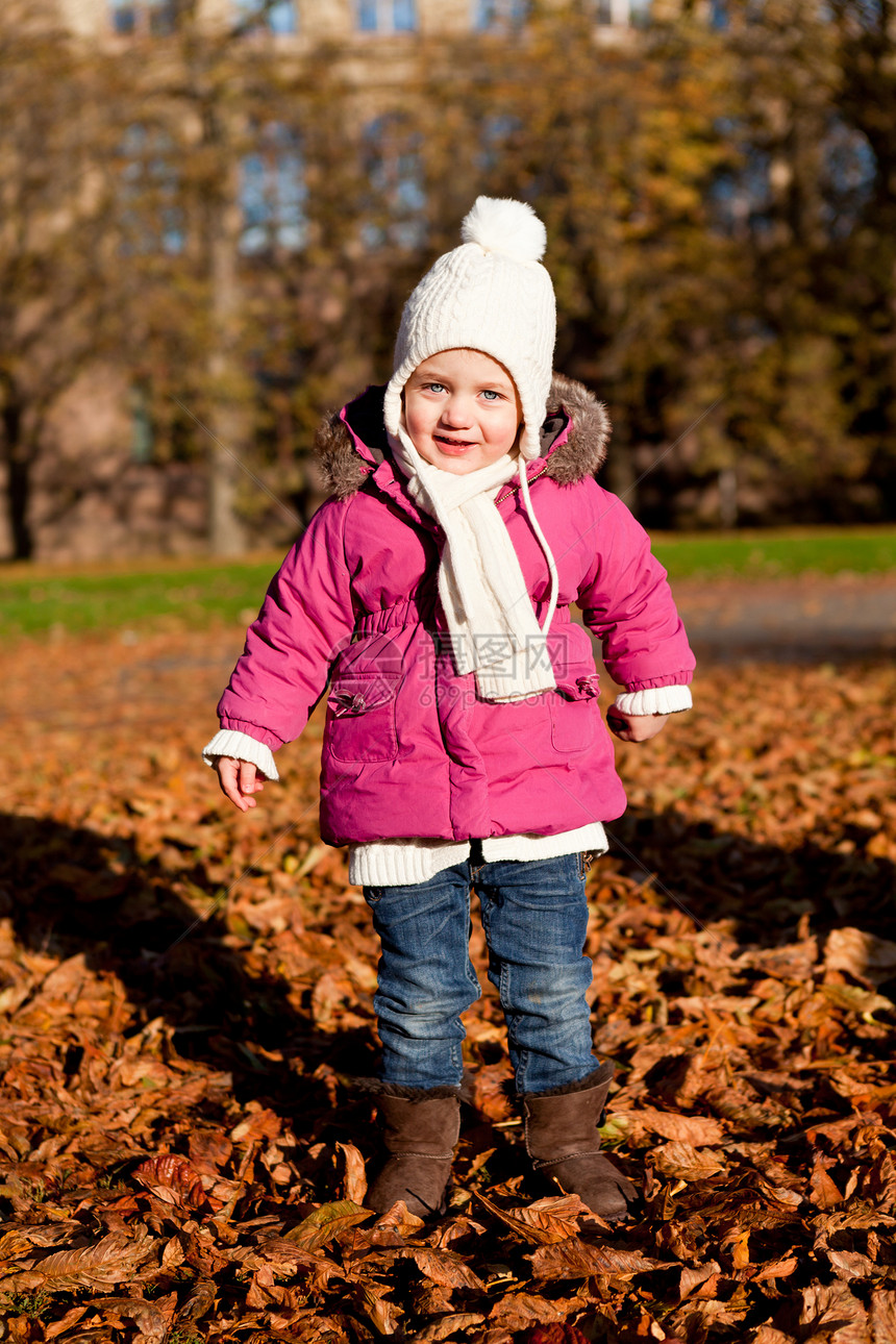 秋天在户外玩耍的可爱女孩乐趣围巾幸福女性公园橙子活动季节童年森林图片