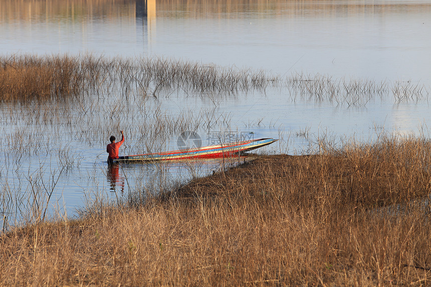 湖边木船上渔民的轮廓活动日落发动机闲暇娱乐风景爱好假期家庭反射图片