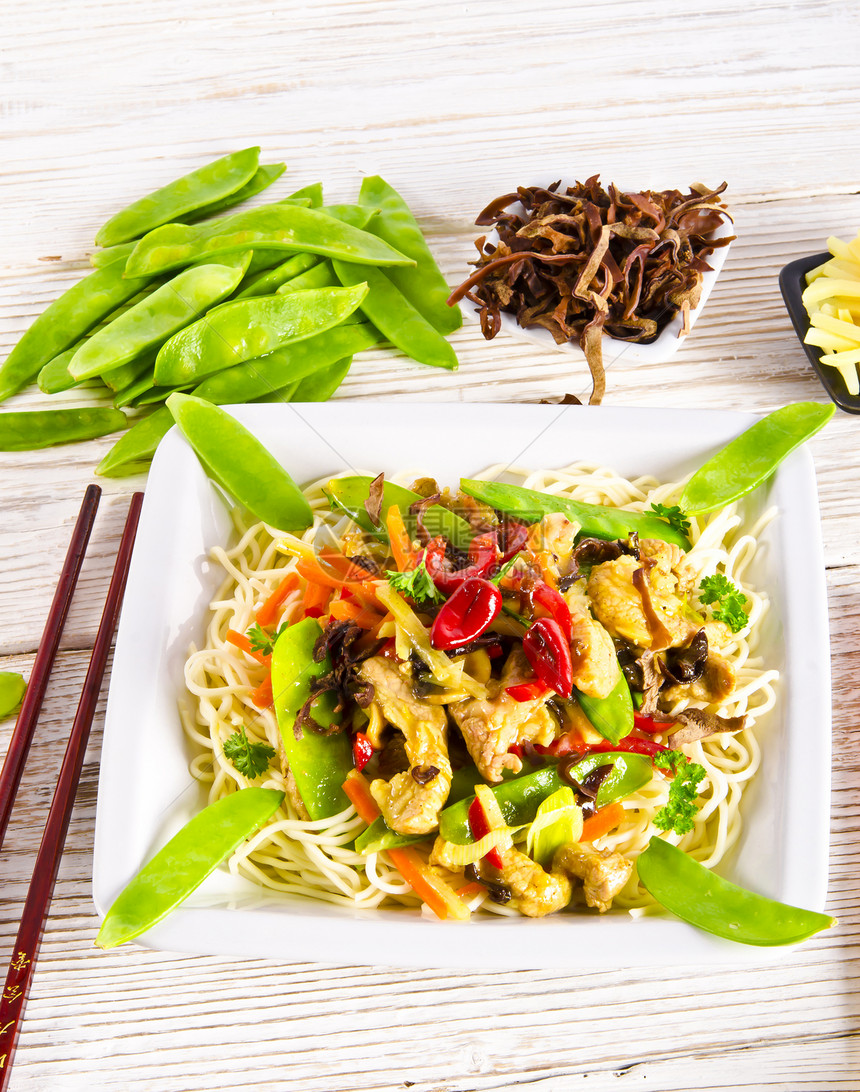 带猪肉和蔬菜的面条盘子小牛竹子烹饪食品炒锅牛扒筷子胡椒食物图片