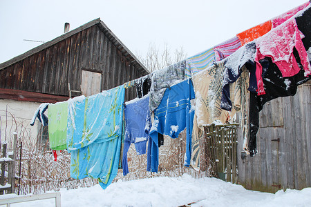 衣服潮湿冬天在绳子上悬吊的洗涤背景