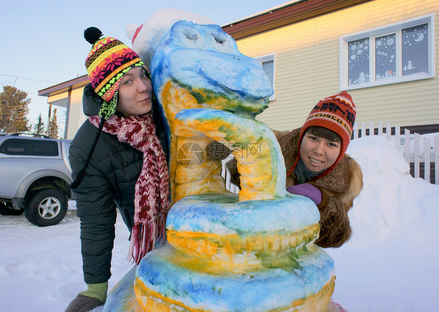 女孩们靠近雪雕像 近距离接近图片