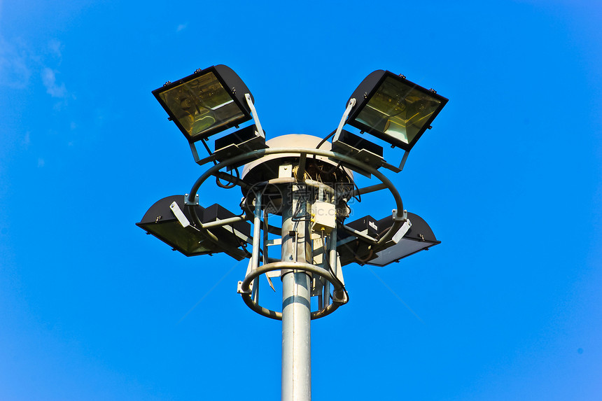 蓝色天空背景上的光极场地游戏路灯光灯反光板灯泡金属灯柱交通足球图片