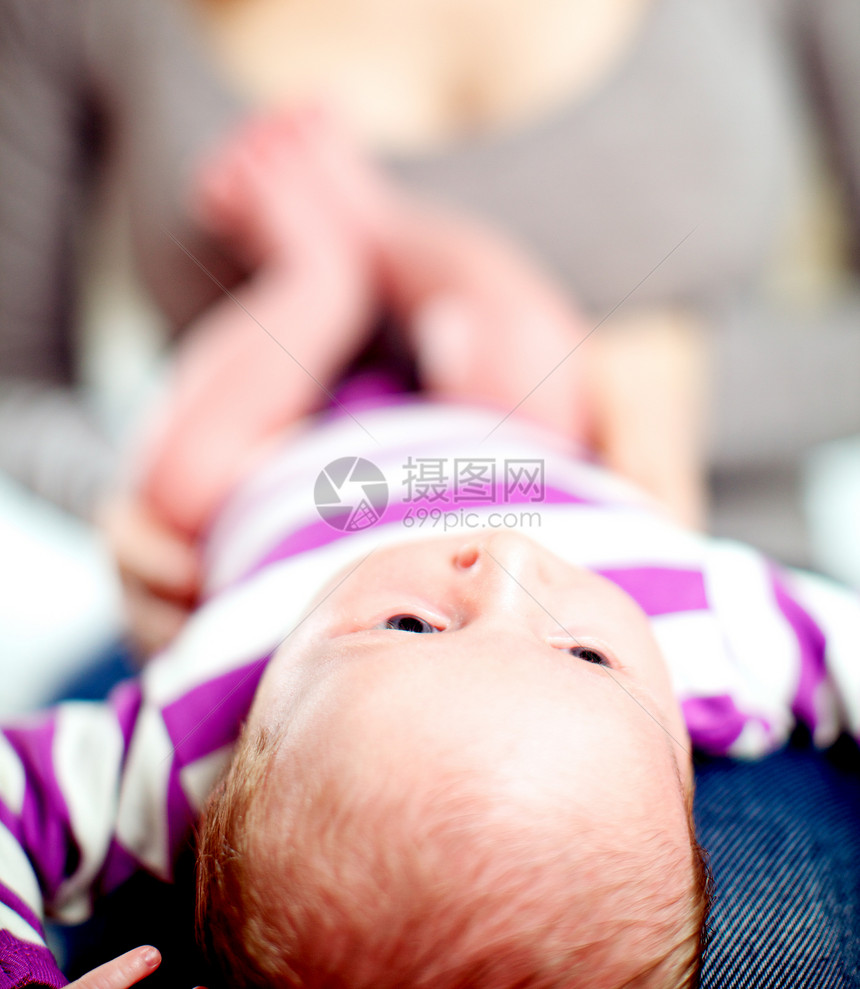 幼小的婴儿躺在母亲的膝上图片