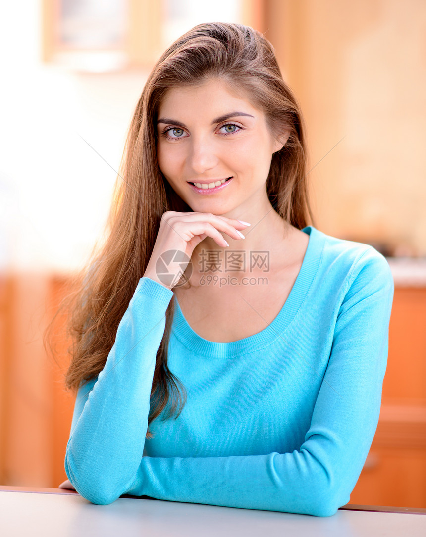 一个美丽的年轻女士的肖像 坐在家里厨房的厨房里微笑着笑女性房子幸福闲暇房间白色成人女孩快乐图片