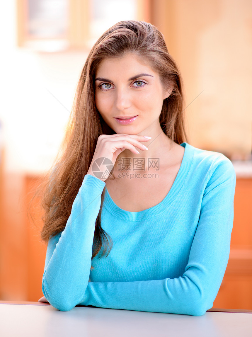 一个美丽的年轻女士的肖像 坐在家里厨房的厨房里微笑着笑房子白色闲暇成人幸福房间女性女孩快乐图片