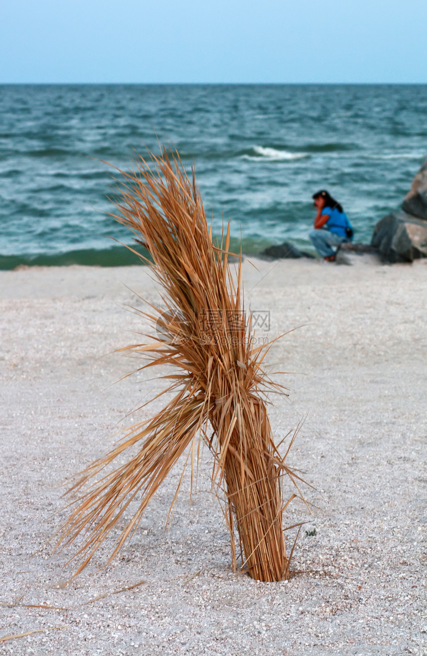 沙滩对岸海边的一帮稻草和轮光坐着图片