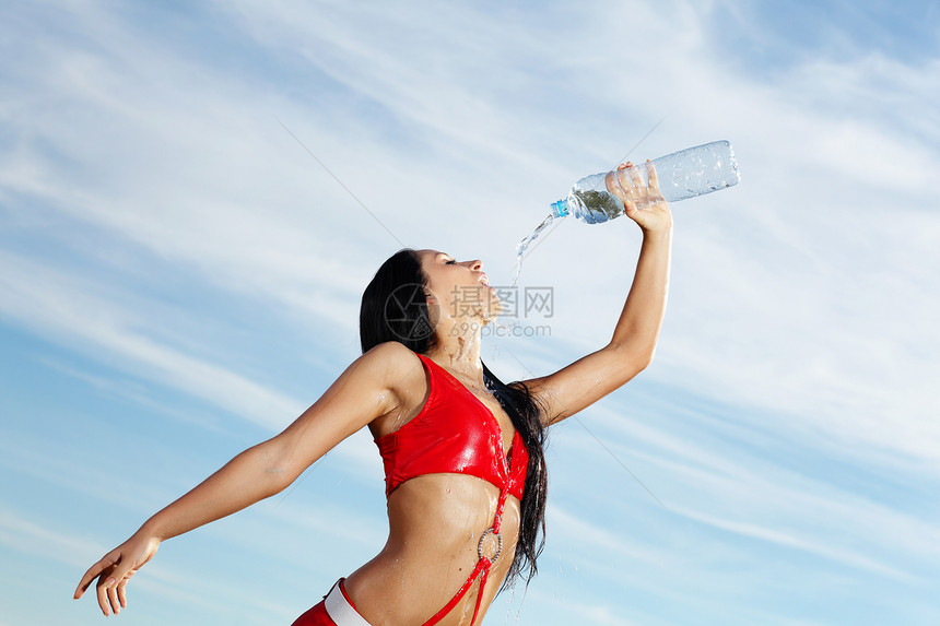 年轻女运动女青年 喝一瓶水运动员成人工作室女孩女性口渴黑发锻炼女士矿物图片