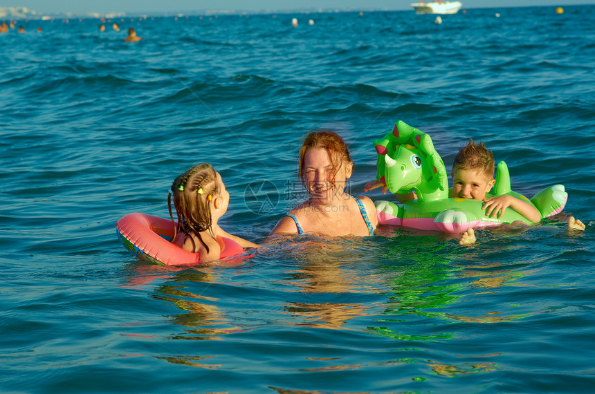 在波浪中的家庭喜悦晴天乐趣季节海浪海滩海洋蓝色假期童年图片