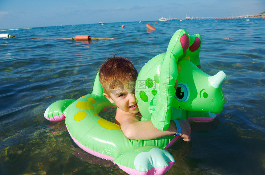 在海浪中的小男孩海洋孩子晴天蓝色假期乐趣喜悦季节童年美丽图片