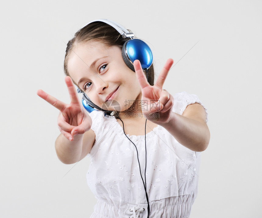 戴耳机的年轻女孩微笑孩子手势童年女性快乐乐趣音乐小姑娘图片