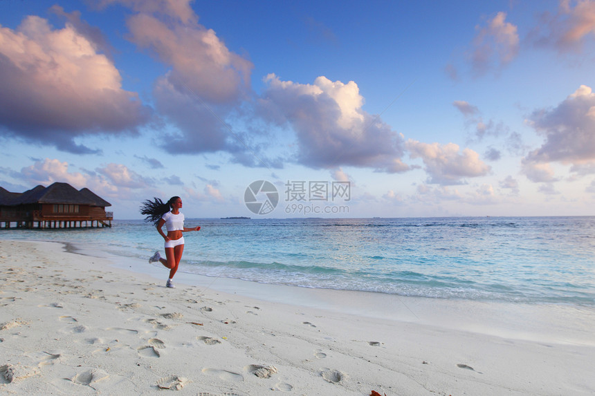 女人在海滩上奔跑慢跑者黑发日落成人天空女性慢跑赛跑者训练运动员图片