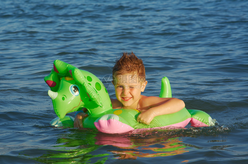 在海浪中的小男孩晴天孩子海滩童年喜悦乐趣假期季节蓝色海洋图片
