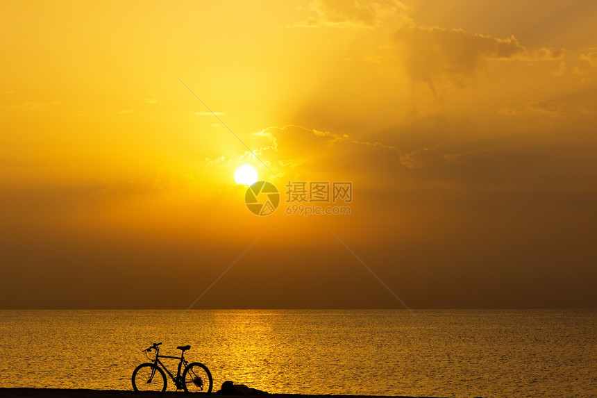 环形车轮运动日落成人阳光射线金子自行车太阳海滩海洋图片