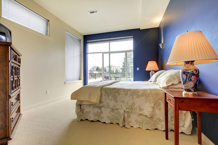 有蓝墙和亚洲灯的床房图片