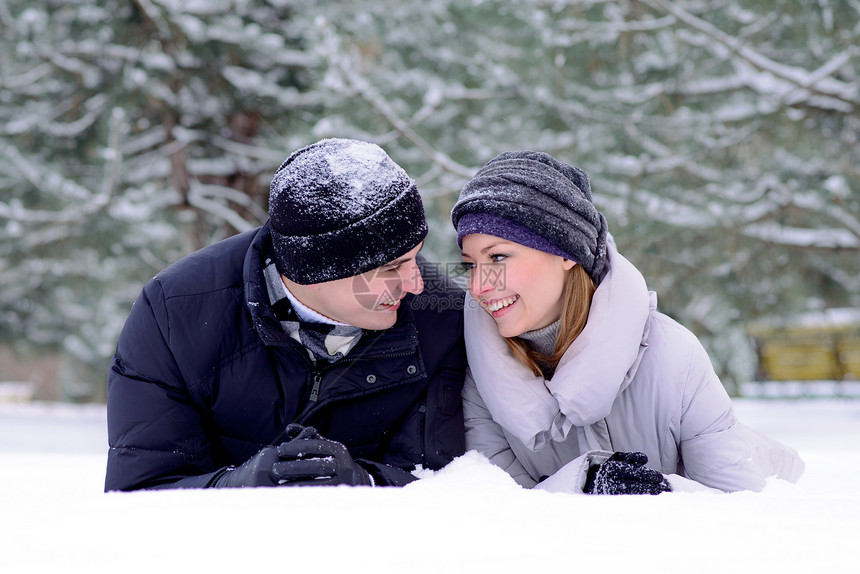 年轻微笑的情侣在雪上撒谎的肖像家庭幸福男性女士拉伸成人男人快乐女性女孩图片