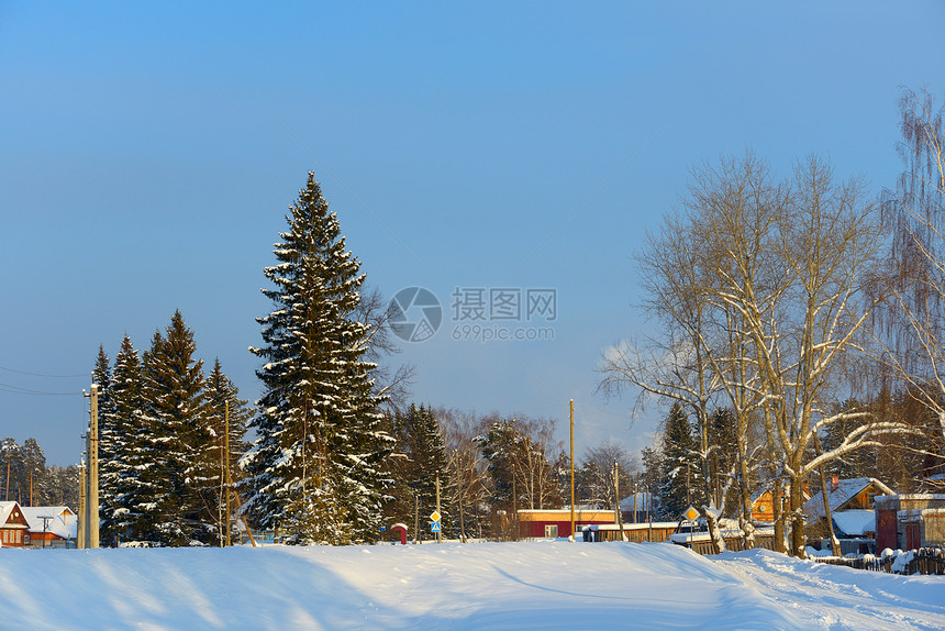 雪覆盖村庄 公路上有三角屋顶栅栏木头小木屋建筑天空松树住宅房子季节舒适图片
