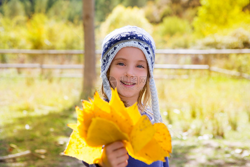 秋天的童女儿童 在阴花林中 黄色落叶手握着童年女性快乐森林眼睛帽子女孩公园树干微笑图片