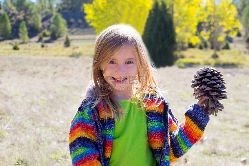 冬季秋天抱着松锥鱼的小女孩季节松树幸福森林眼睛童年羊毛草地外套快乐图片