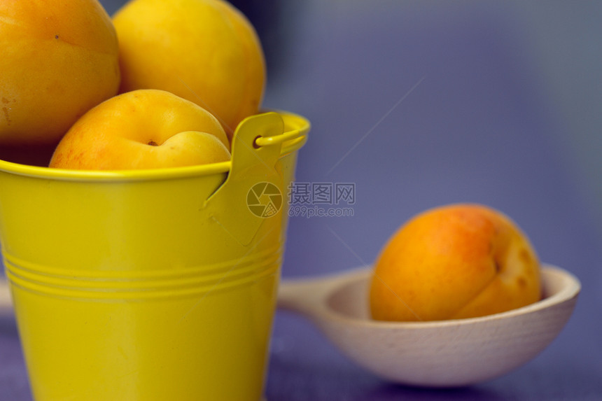 一个小黄桶中的杏子桌子团体果汁木头金属花园水果工作室食物甜点图片