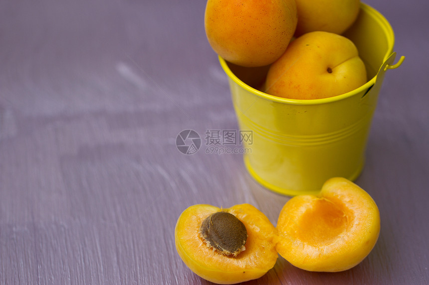 一个小黄桶中的杏子叶子饮食小吃食物甜点桌子团体蔬菜收成金属图片
