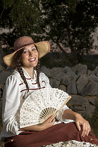农村的漂亮女孩古董红色女士裙子梦幻帽子怀旧扇子公园白色背景图片