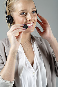 工作时戴耳头帽的妇女呼叫微笑电话商业耳机女士女性办公室快乐中心背景图片