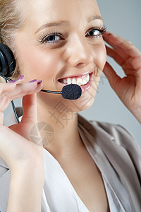 工作时戴耳头帽的妇女女性商业女士办公室电话中心快乐呼叫微笑耳机背景图片