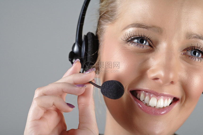 工作时戴耳头帽的妇女微笑电话耳机商业呼叫女士快乐中心女性办公室图片