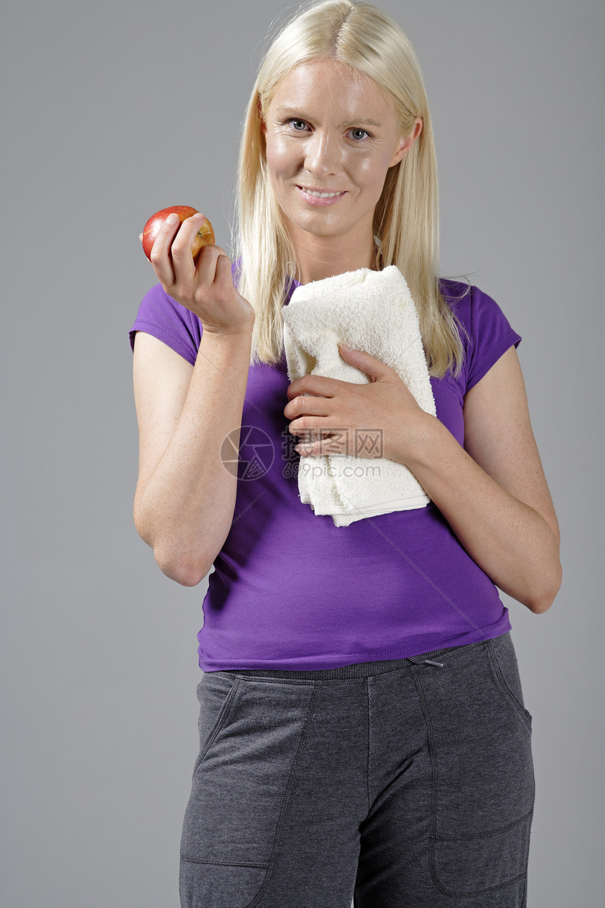 健身后持有苹果的妇女运动女孩水果女性金发女郎女士快乐图片