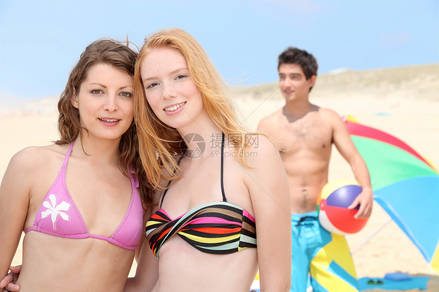 海滩上的青少年假期青年男人太阳冒充少年沙丘女孩们射线阴影图片