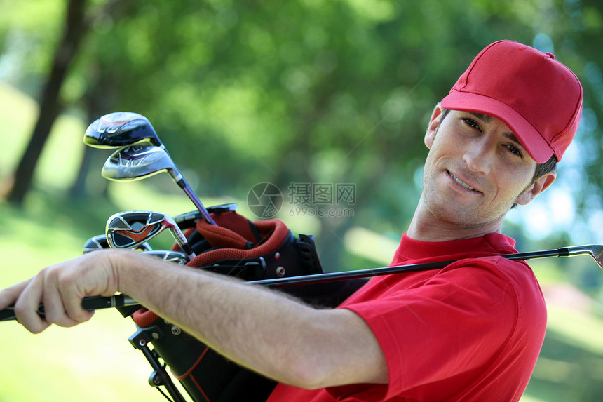 高尔夫球把俱乐部放在他的肩膀上图片